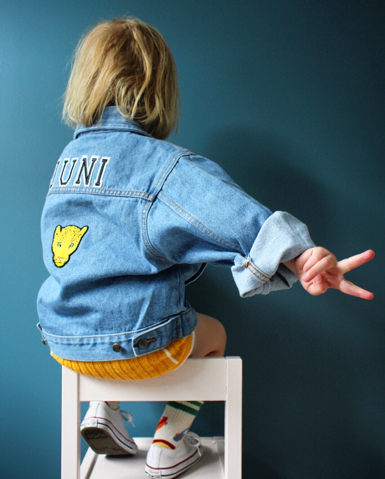 Juni wearing a denim jacket with a tiger patch